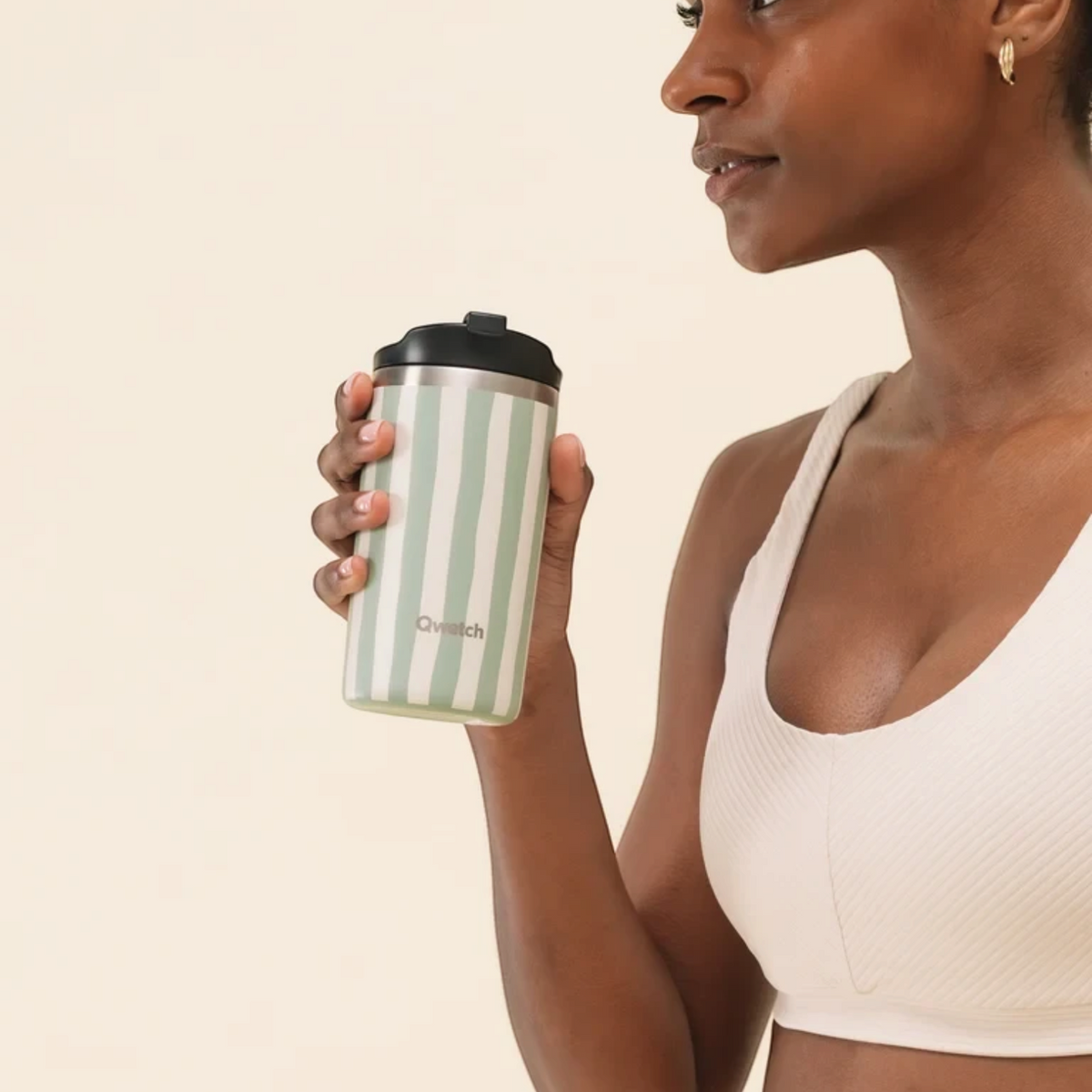Femme tenant un mug isotherme Qwetch rayé vert tilleul et blanc de Du Bruit dans la Cuisine, en acier inoxydable